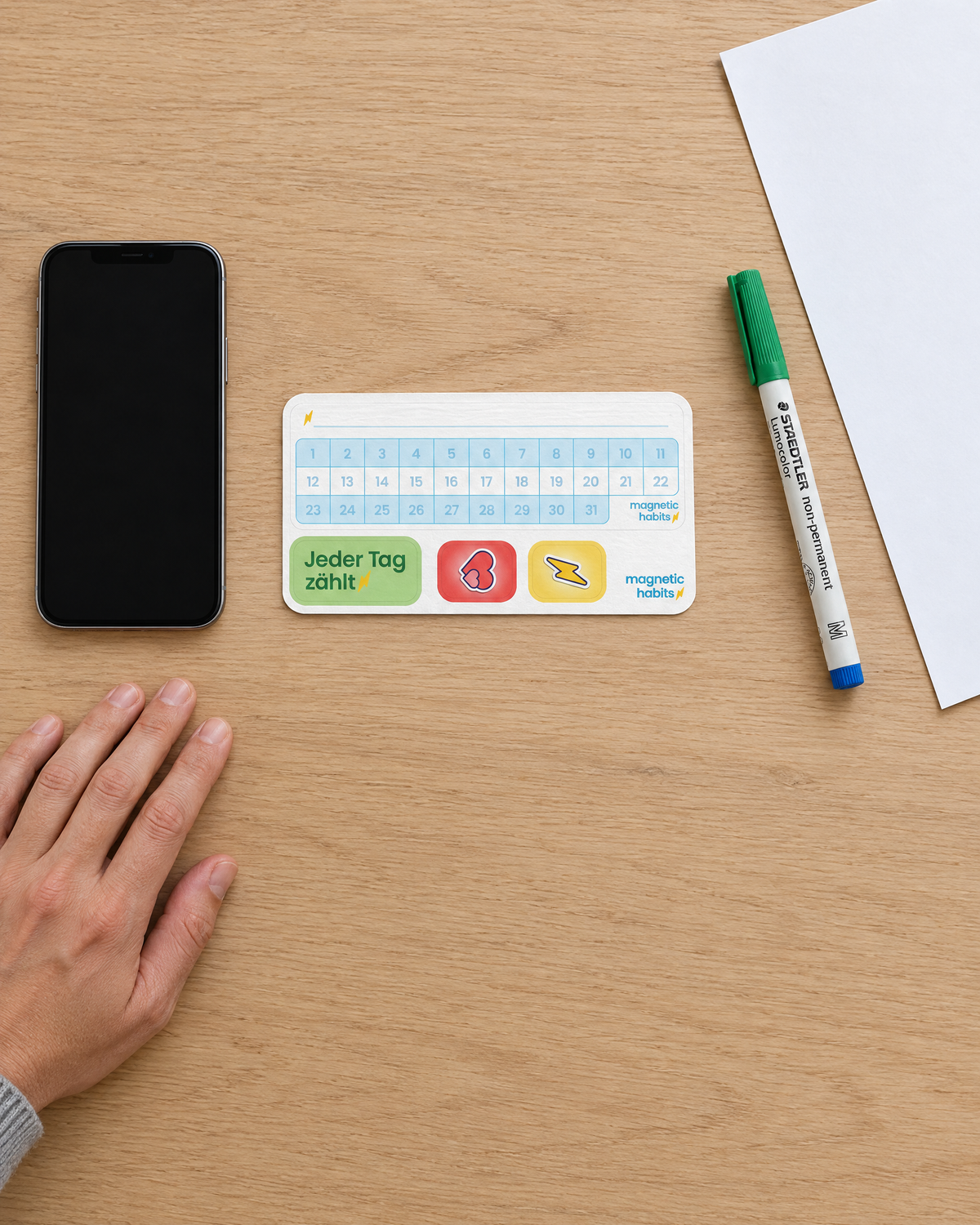 Größenvergleich: 31-Tage-Tracker, 19 × 5,7 cm, neben Handy und Stift (Visualisierung)